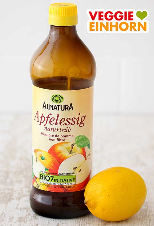 Alnatura Apfelessig naturtrüb und eine Zitrone Eine Flasche Apfelessig und eine Zitrone