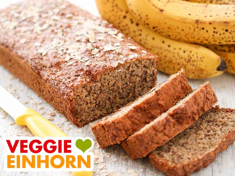 Ein veganes Bananenbrot mit Haferflocken und drei geschnittene Scheiben