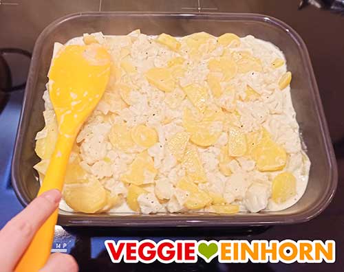 Der vegane Blumenkohlauflauf vor dem Backen Kartoffeln und Blumenkohl mit der veganen Sahne in der Auflaufform