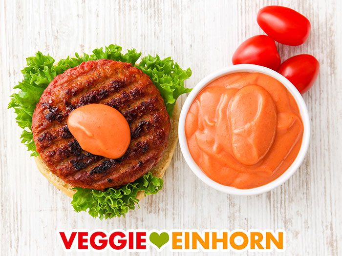 Ein Burger mit Sauce und ein Schälchen mit Burgersauce