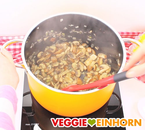 Champignons und Zwiebeln werden mit veganer Margarine im Topf gedünstet