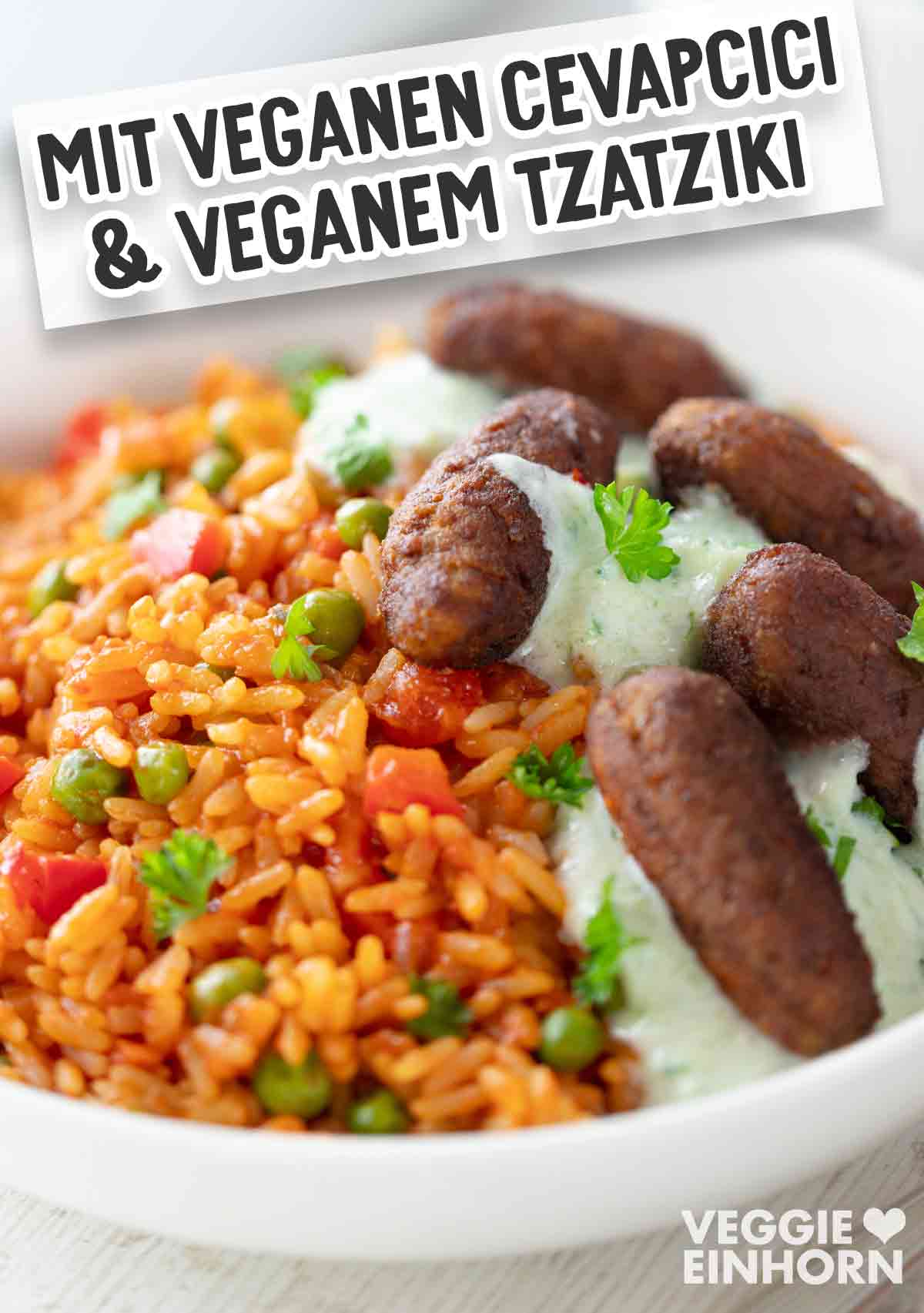 Nahaufnahme eines weißen Tellers mit Djuvec Reis, veganen Cevapcici und veganem Tzatziki, garniert mit frischer Petersilie. Oben im Bild ist ein Schriftbanner mit der Aufschrift „MIT VEGANEN CEVAPCICI & VEGANEM TZATZIKI“.