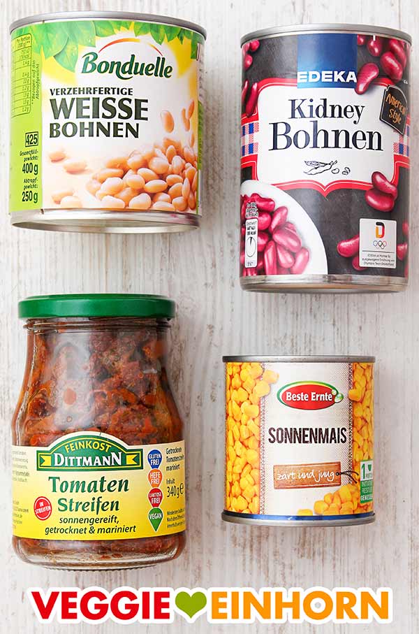 Bohnen und Mais aus der Dose, getrocknete Tomaten in Öl Konservendosen mit weißen Bohnen, Kidneybohnen und Mais und ein Glas getrocknete Tomaten in Öl