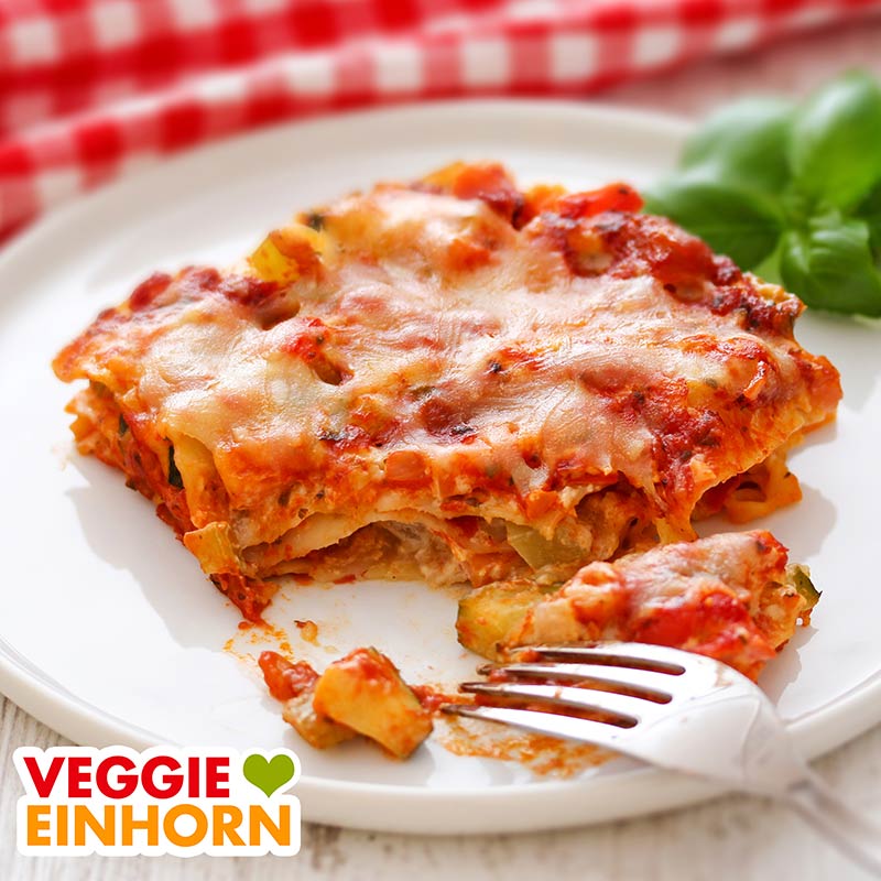 Mit veganem Käse überbackene Gemüselasagne Eine Portion vegane Gemüselasagne mit Crème fraîche