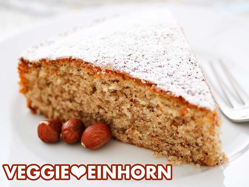 Ein Stück veganer Nusskuchen mit Puderzucker