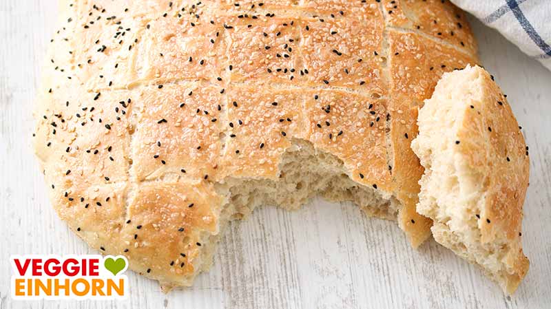 Das türkische Fladenbrot ist vegan. Türkisches Fladenbrot und ein abgebrochenes Stück Brot