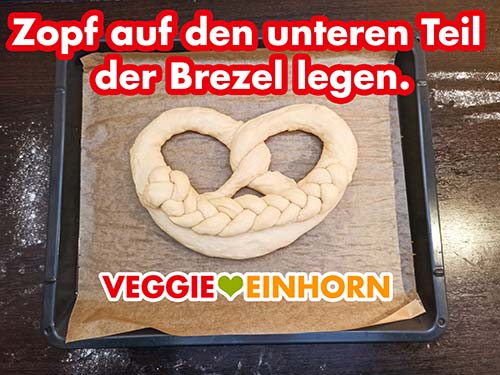 Zopf auf den unteren Teil der Brezel legen Der Zopf aus Hefeteig liegt auf der Neujahrsbrezel