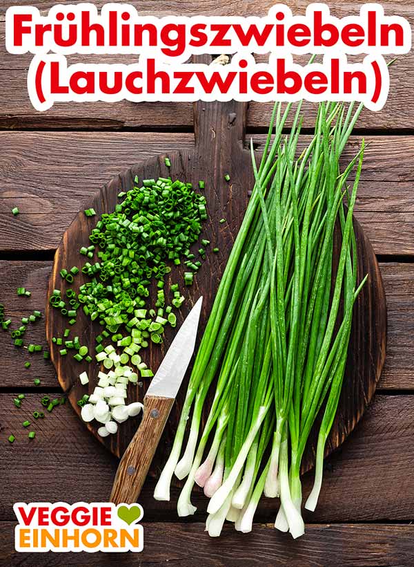 Frühlingszwiebeln auf einem Holzbrett