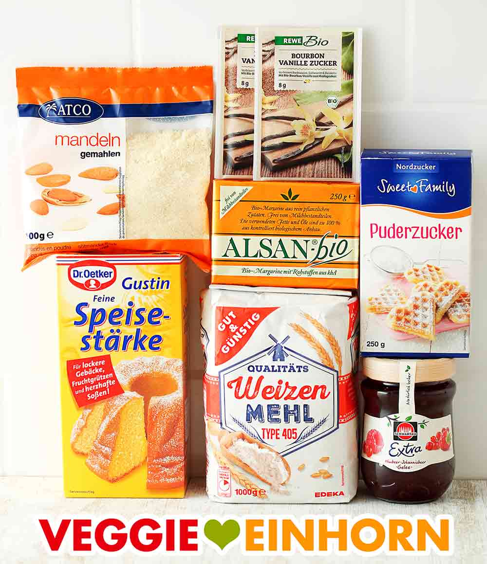 Zutaten für vegane Engelsaugen Gemahlene Mandeln, Vanillezucker, Speisestärke, vegane Butter, Mehl, Puderzucker, ein Glas Himbeer-Johannisbeer-Gelee