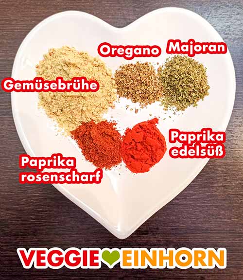 Gemüsebrühe Pulver, Oregano, Majoran, Paprika rosenscharf, Paprika edelsüß Gewürze für den Rote Linsen Eintopf auf einem herzförmigen Teller
