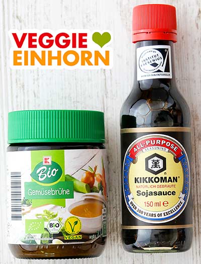 Ein Glas Gemüsebrühe und eine Flasche Sojasauce