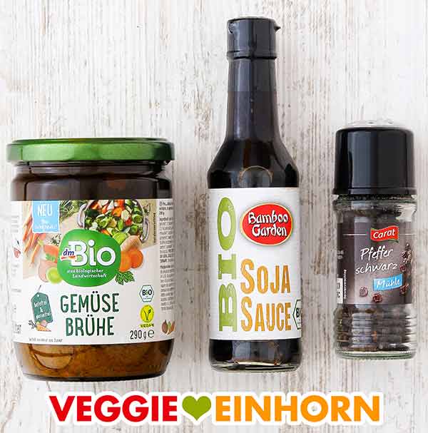 Ein Glas Gemüsebrühe Pulver, eine Flasche Sojasauce, eine Pfeffermühle