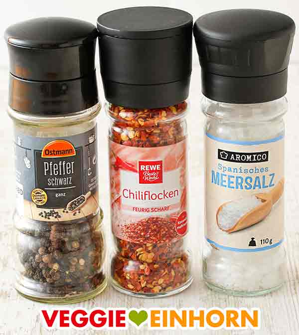 Pfeffer, Chili und Salz Drei Gewürzmühlen mit schwarzem Pfeffer, Chiliflocken und Meersalz