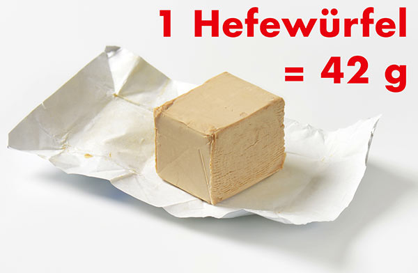 Ein Hefewürfel liegt ausgepackt auf dem Papier