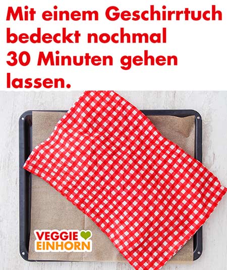 Hefezopf auf dem Backblech mit einem Geschirrtuch bedeckt