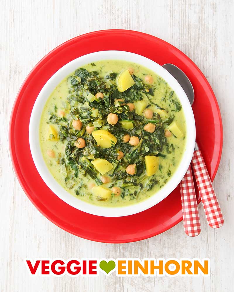 Vegane Suppe mit Kartoffeln und Spinat Ein Teller mit veganer Kartoffel Spinat Suppe