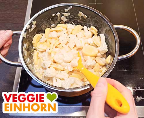 Kartoffeln, Blumenkohl und Soja Cuisine mit Gewürzen im Topf Die vegane Sahne, Kartoffeln und Blumenkohl im Topf