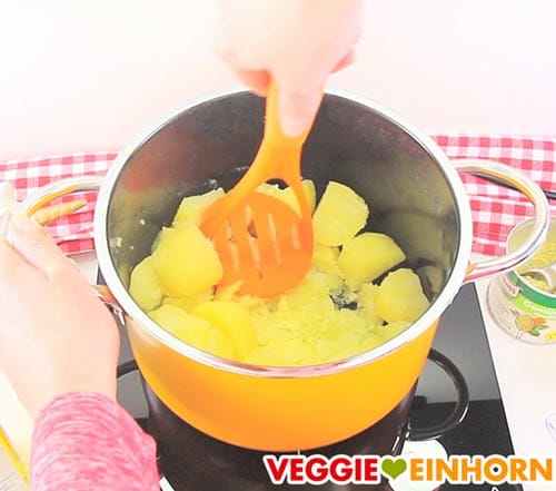Gekochte Kartoffeln stampfen mit Kartoffelstampfer