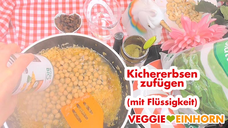 Kichererbsen und Kichererbsenwasser aus der Dose zugeben. Eine Dose Kichererbsen mit Flüssigkeit wird in die Pfanne zugefügt.