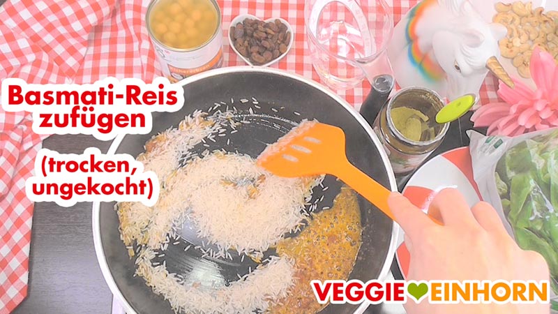 Der Basmati Reis wird trocken und ungekocht zugefügt. Basmati Reis in der Pfanne