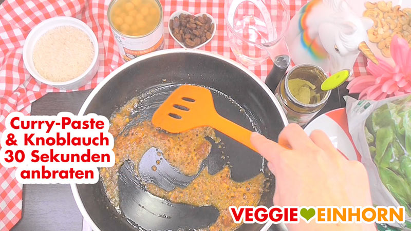 Vegane rote Curry Paste und Knoblauch in der Pfanne Rote Currypaste und Knoblauch anbraten