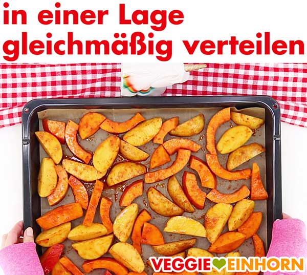 Kürbis und Kartoffelspalten in einer Lage auf dem Blech.