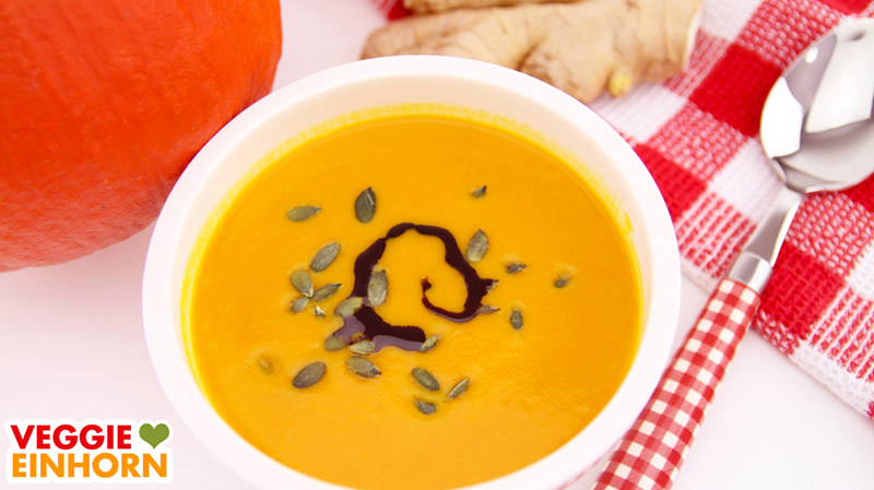 Kürbissuppe serviert mit Kürbiskernen und Kürbiskernöl