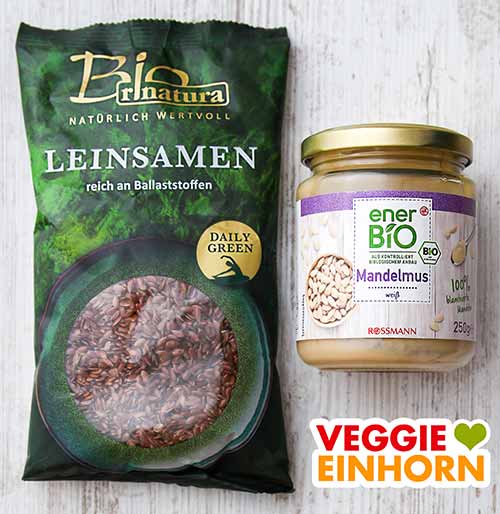 Leinsamen und weißes Mandelmus Eine Packung Leinsamen und ein Glas weißes Mandelmus