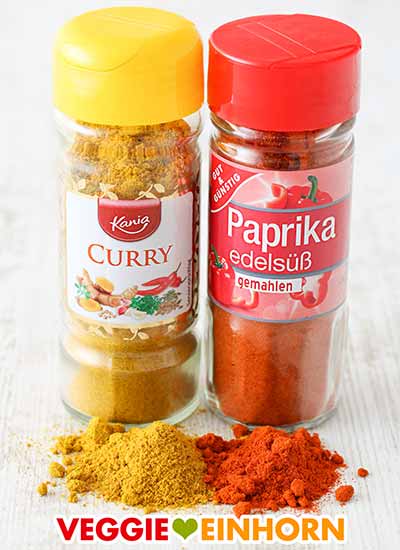 Currypulver und Paprika edelsüß Zwei Gewürzgläser mit Curry und Paprika edelsüß Pulver