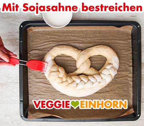 Vor dem Backen wird die Neujahrsbrezel mit veganer Sahne bepinselt Die Neujahrsbrezel wird mit Soja Cuisine bestrichen
