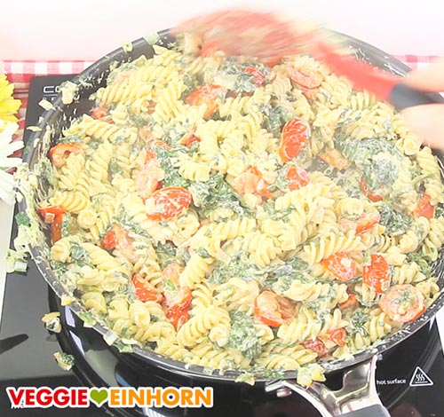 Nudeln mit veganer Frischkäse-Soße, Tomaten und Blattspinat in der Pfanne