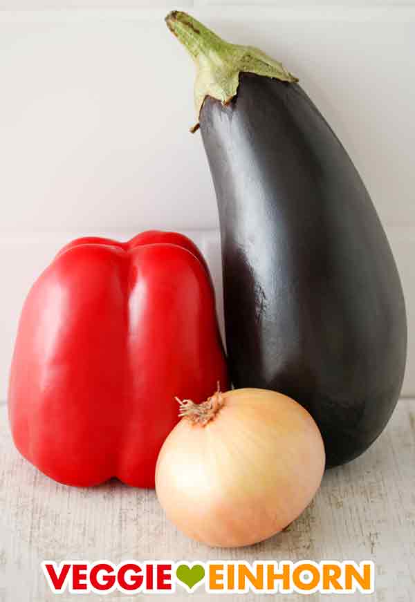 Rote Paprika, Aubergine und eine große Zwiebel Eine Paprika, eine Aubergine und eine Zwiebel