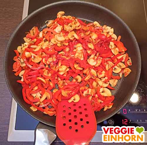 Knoblauch und Tomatenmark mit anbraten. Paprika und Pilze mit Tomatenmark und Knoblauch in der Pfanne