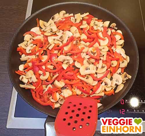 Gemüse nach 5 Minuten Angebratene Paprika und Champignons in einer Pfanne