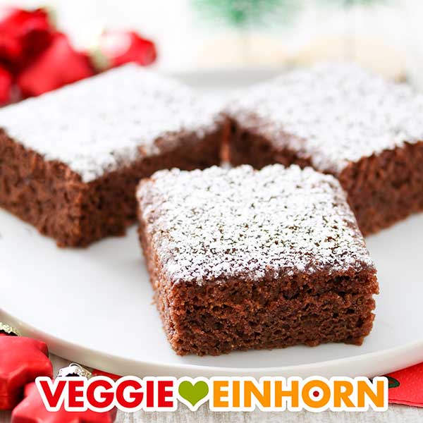 Veganer Lebkuchen vom Blech mit Puderzucker Drei Stück Lebkuchen vom Blech auf einem weißen Teller