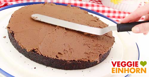 Sahnecreme verteilen auf der veganen Schokotorte Sahnecreme verteilen auf der veganen Schokotorte