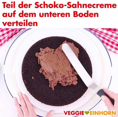 Vegane Schoko-Sahnecreme auf dem unteren Boden verteilen Vegane Schoko-Sahnecreme auf dem unteren Boden verteilen