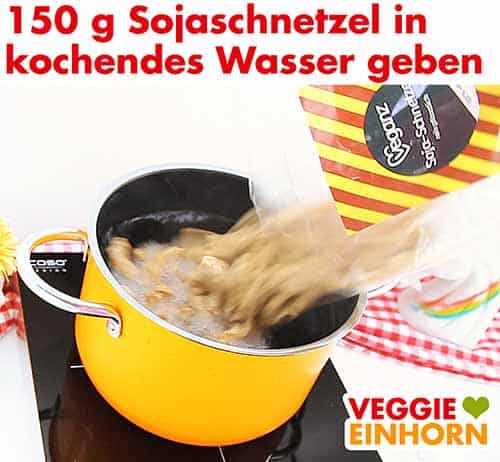 Sojaschnetzel in einen Topf mit kochendem Wasser geben Sojaschnetzel in einen Topf mit kochendem Wasser geben