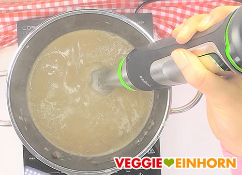 Vegane Champignonsuppe wird mit Stabmixer püriert