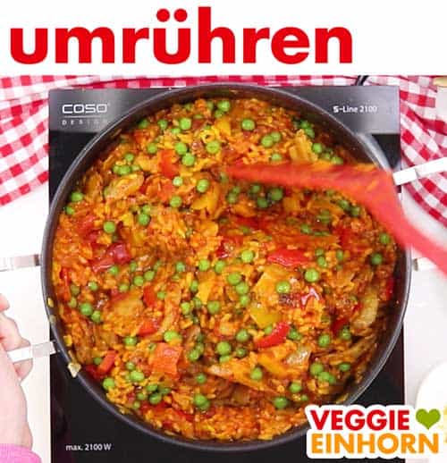 Vegane Gemüse Paella wird in Pfanne umgerührt