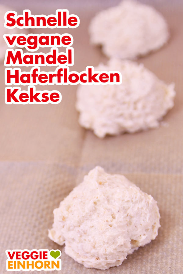Teig für die veganen Haferflockenkekse mit Mandeln auf dem Backblech mit Backpapier Teighäufchen auf dem Backpapier