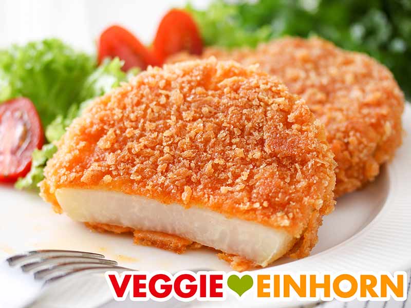 Zwei vegane Kohlrabischnitzel auf einem Teller mit Salat 