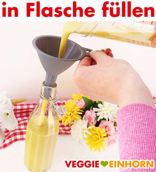 Eierlikör wird mit Trichter in Flasche gefüllt