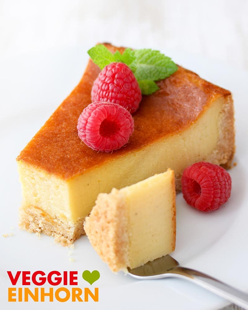 Ein Stück veganer Käsekuchen ist dekoriert mit frischen Himbeeren. Veganer Käsekuchen serviert mit Himbeeren