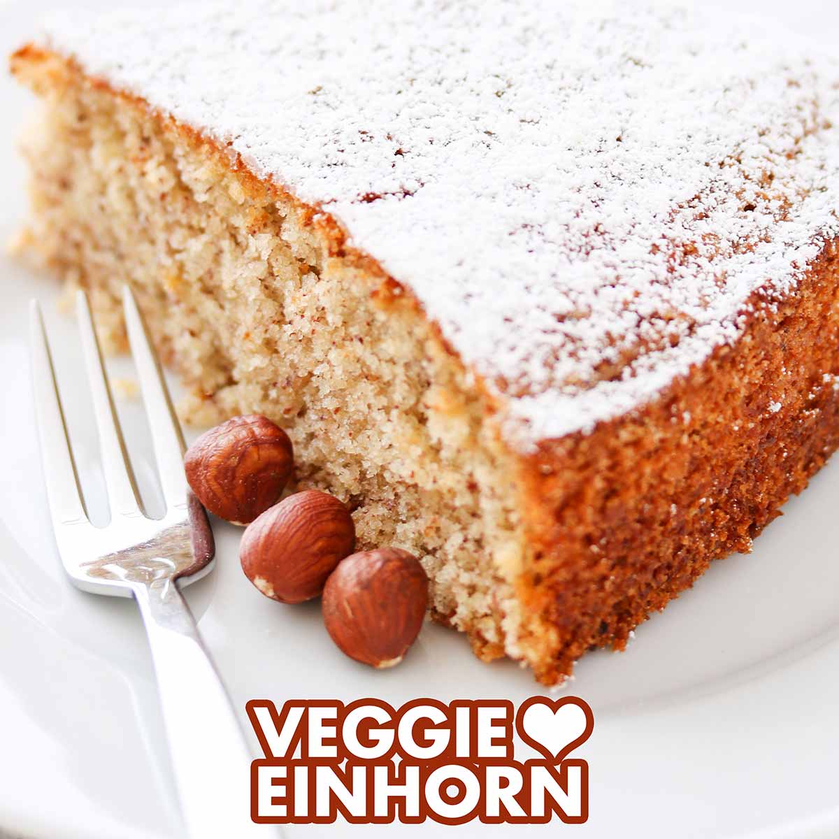 Veganer Nusskuchen auf einem Teller mit einer Kuchengabel