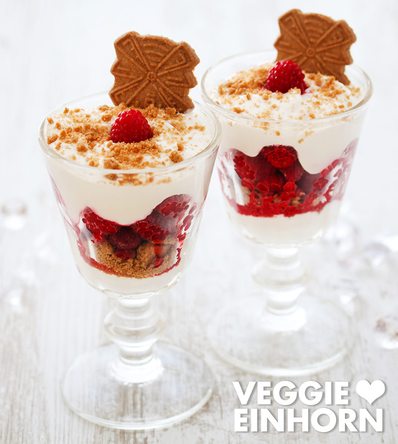 Zwei Dessertgläser mit Spekulatius, Himbeeren und Creme