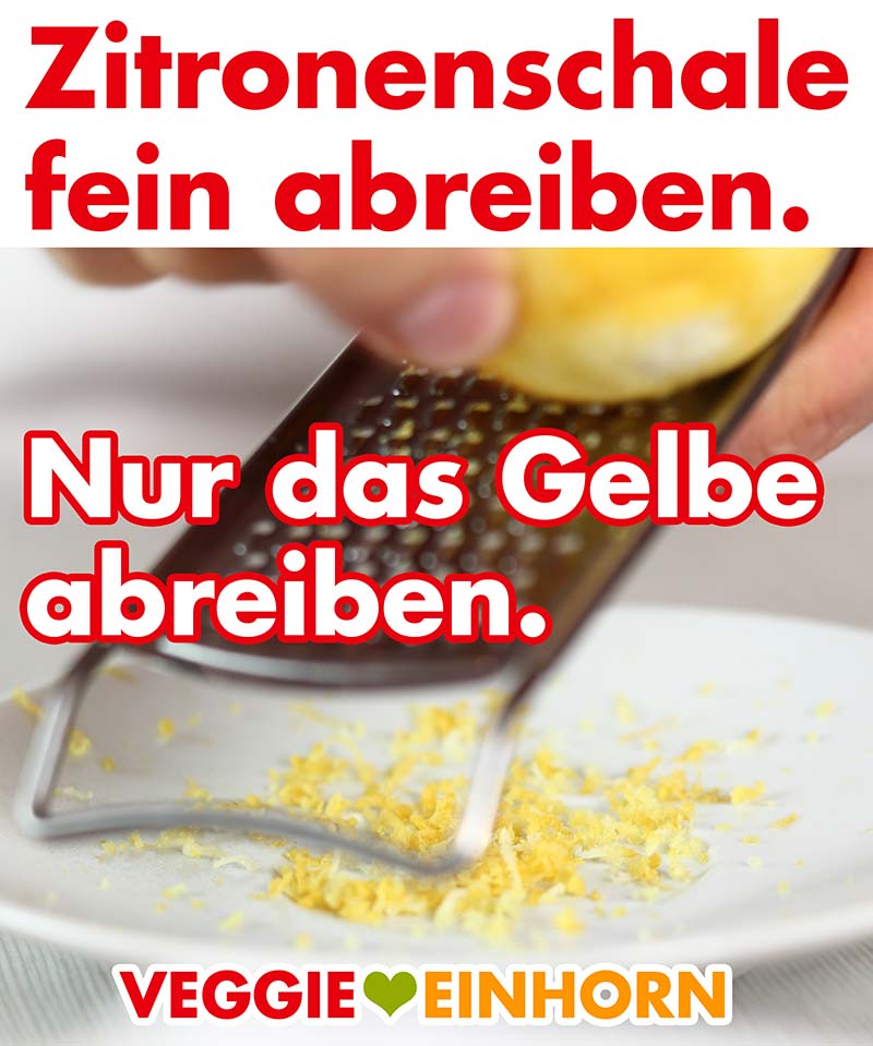 Eine Reibe und abgeriebene Zitronenschale auf einem Teller