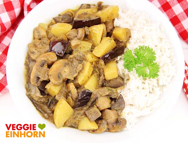 Als Beilage schmeckt Basmati Reis. Kartoffel Auberginen Curry mit Reis auf einem Teller
