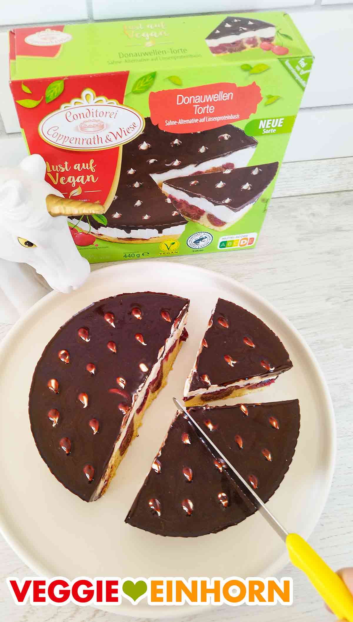Aufschneiden der veganen Donauwellen Torte von Coppenrath und Wiese Die vegane Donauwelle von Coppenrath und Wiese wird in Stücke geschnitten.