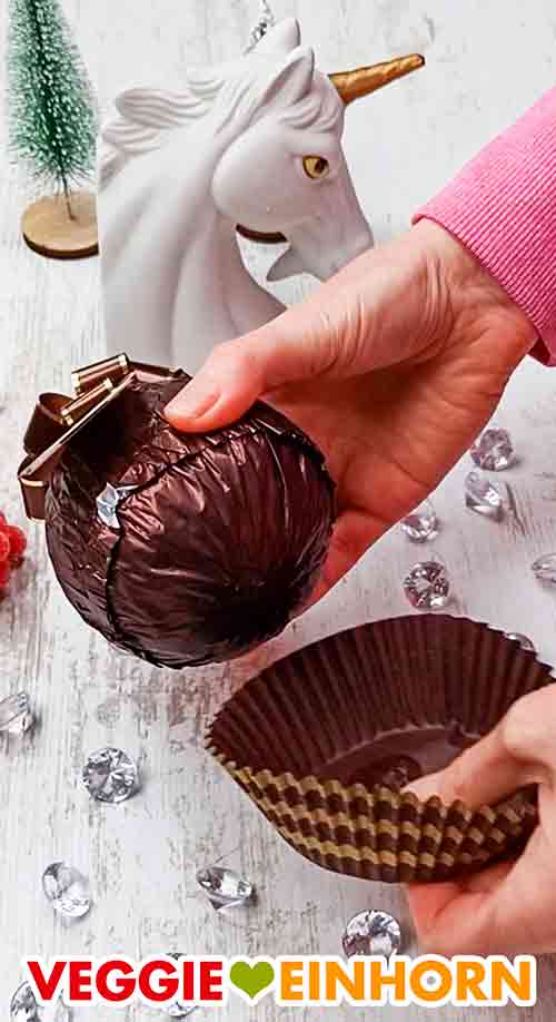 Das vegane Grand Ferrero Rocher wird ausgepackt. Die Kugel des Grand Ferrero Rocher Zarbitter und die große Pralinenform der Verpackung